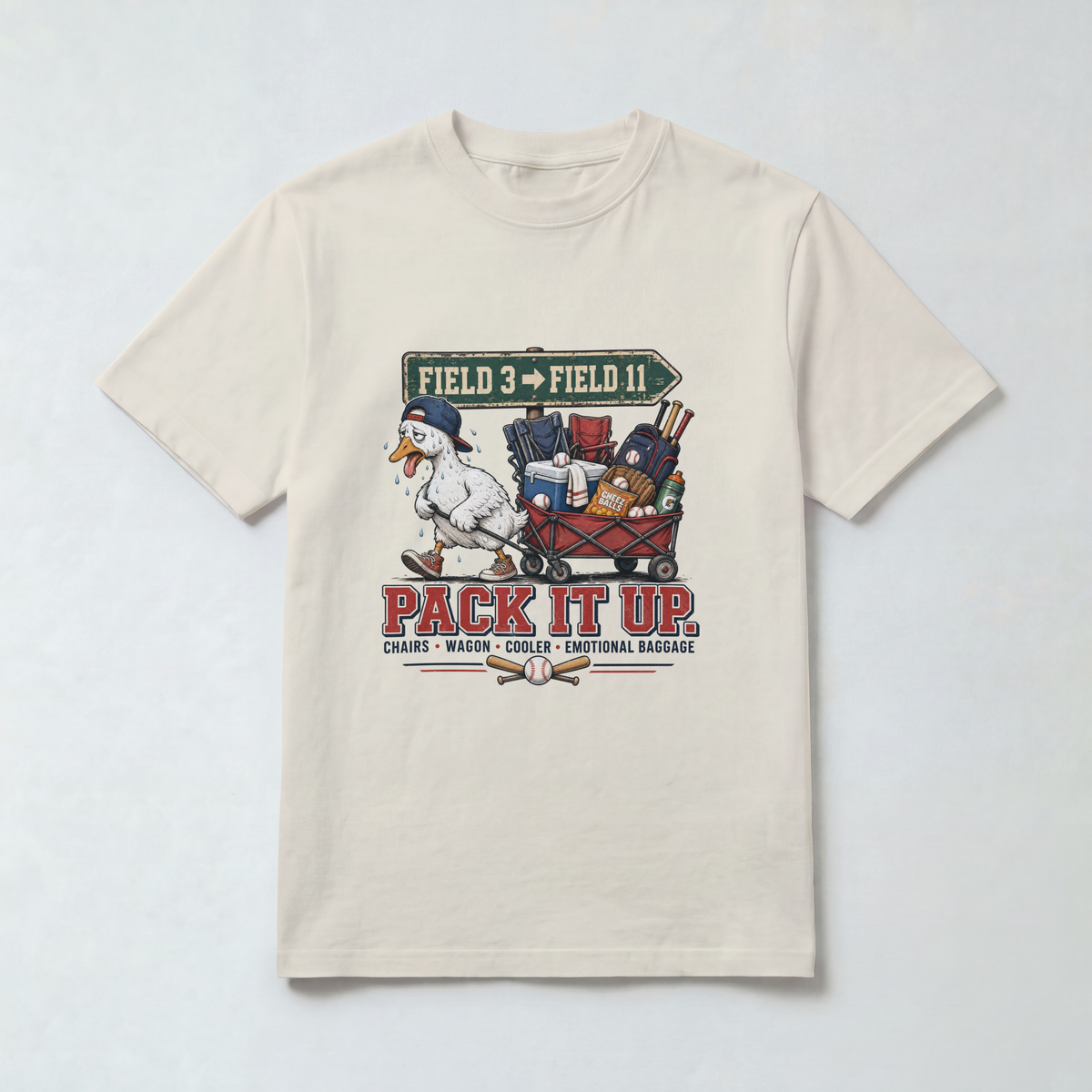 Ivory Comfort Colors 1717 travel baseball parent shirt featuring the Pack It Up goose and tournament wagon design.