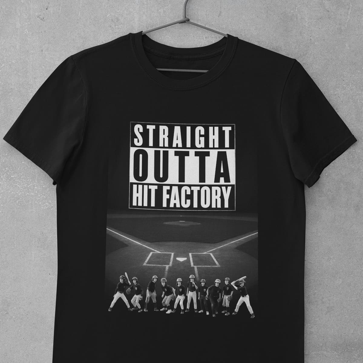 Black custom team apparel t-shirt with bold full-front graphic print on a cement background mockup.